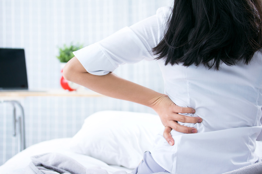 attractive-woman-with-back-pain-home-bedroom