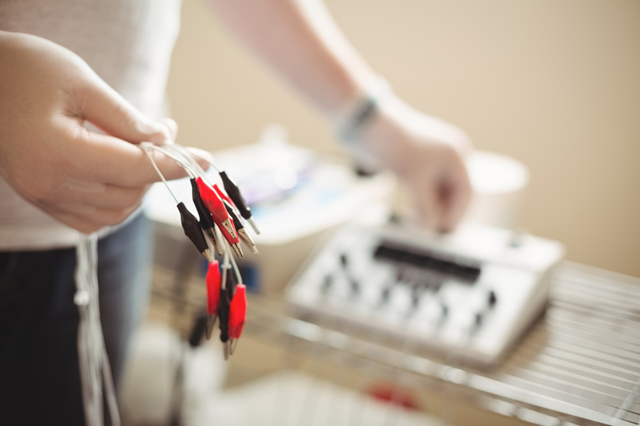 physiotherapist-holding-cable-electro-dry-needling-unit