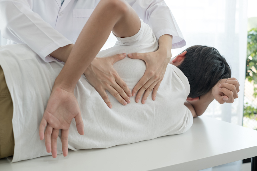 Female physiotherapists provide physical assistance to male patients with back injuries back massages for relaxation and muscle recovery in the rehabilitation center