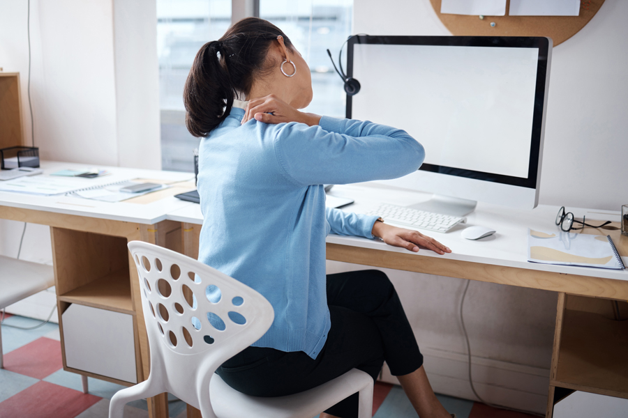 shot-businesswoman-experiencing-back-pain-while-working-her-desk-modern-office