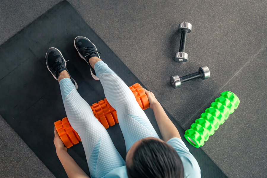 sport-woman-using-foam-roller-muscle-fascia-stretching-foot